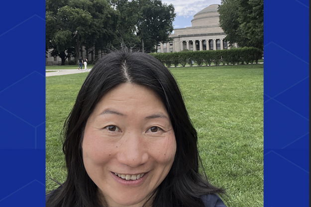 Huilin Tu, standing in front of the MIT dome. Only her head is visible, and she's smiling.